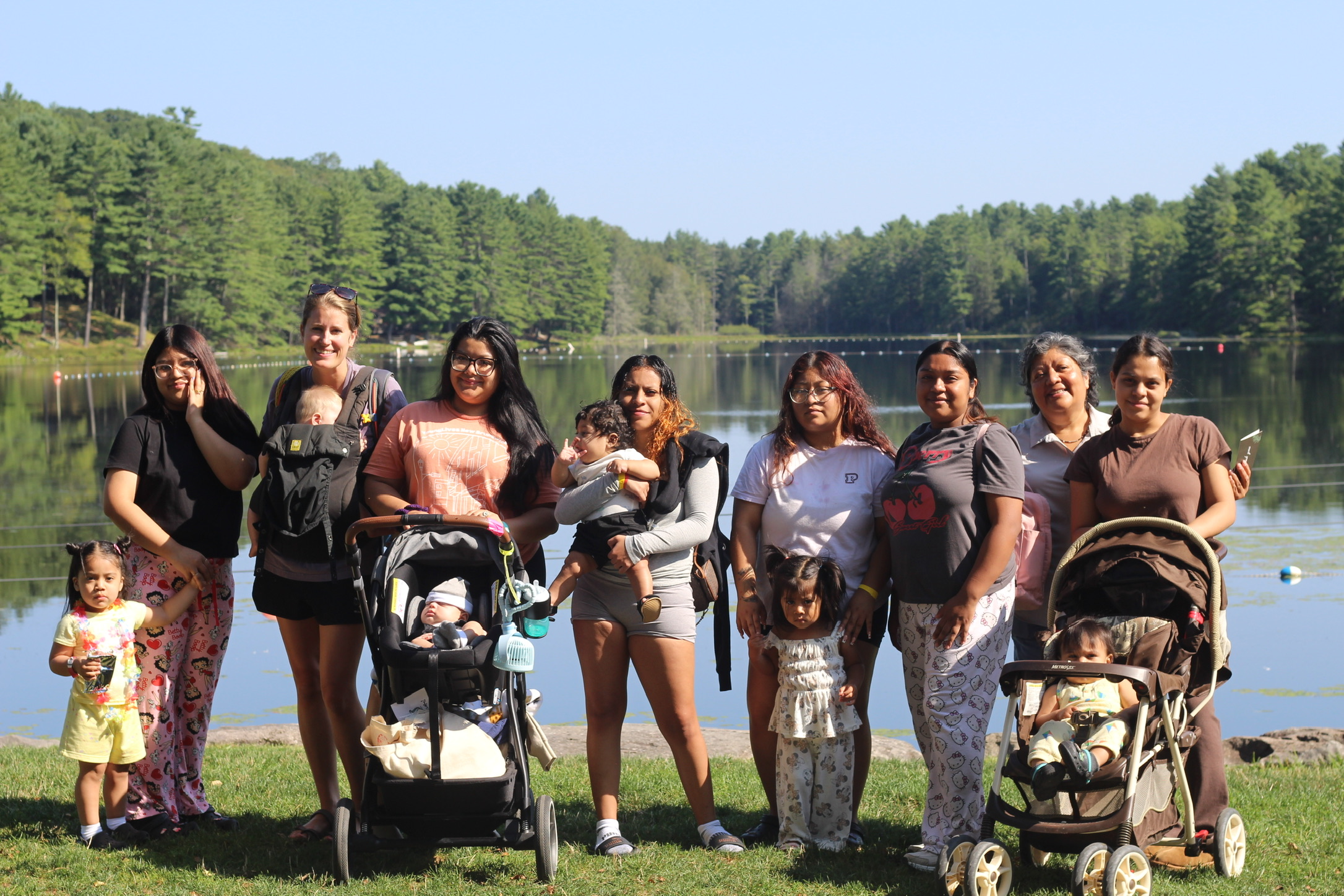 Teen moms and their kids gathered outdoors at summer camp
